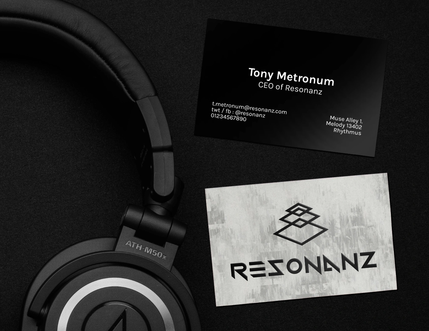 Corporate Identity. Resonanz Branding auf Visitenkarte. Schwarzes Logo auf weißem Hintergrung, mit Kontaktdetails im weißen Schrift und schwarzen Hintergrund. Es ist neben Kopfhörer gelegt.